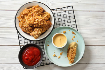 Tasty nuggets with sauces on white table