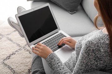 Young woman working on laptop at home