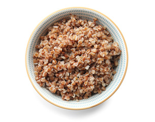 Bowl with tasty boiled buckwheat on white background