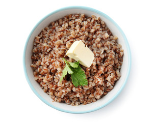 Bowl with tasty boiled buckwheat on white background