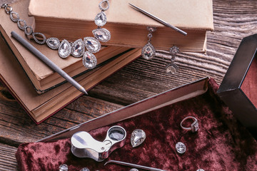Beautiful jewelry with precious stones and tools on wooden table