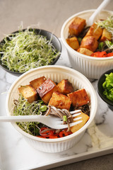 Bowls with tasty fried tofu cheese and soba noodles on table