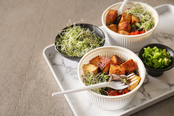 Bowls with tasty fried tofu cheese and soba noodles on table