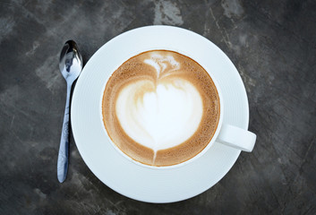 Beautiful art of Hot latte coffee in white cup on cement table background, top view