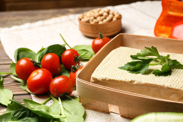 Tasty tofu cheese with vegetables on table