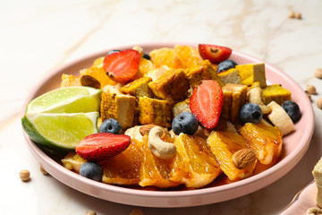 Plate with healthy tofu salad on light table