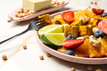 Plate with healthy tofu salad on light table