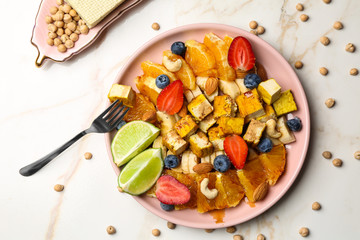Plate with healthy tofu salad on light table