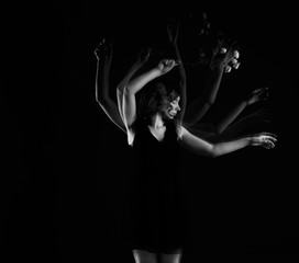 Stroboscopic photo of beautiful moving young woman on dark background