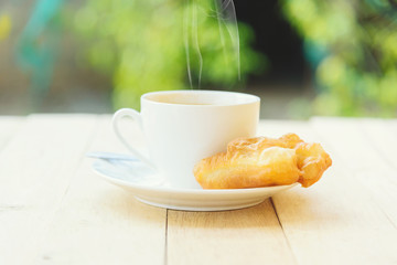 hot coffee with deep-fried dough stick / coffee with deep-fried dough stick on wood table