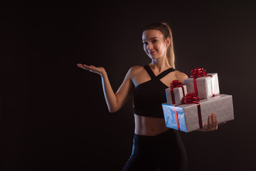 athletic blonde holding  many gift boxes 