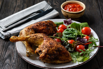 Grilled chicken leg quorters with salad mix and tomatoes.