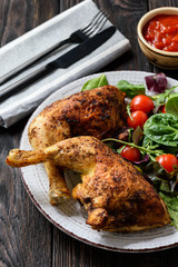 Grilled chicken leg quorters with salad mix and tomatoes.