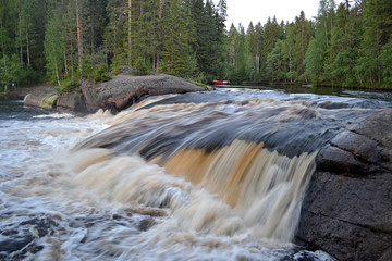 Rapids-waterfall (Rozovy Slon) Pink Elephant on the river of Uksunjoki, Kola peninsula. Brownish water flows through the rapids. Rapids for rafting. Long-exposure photo