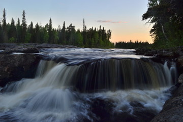 Fototapeta na wymiar Waterfall on the river on a long exposure against the sunset