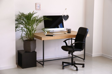 Stylish workplace with modern computer in interior of room