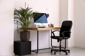 Stylish workplace with modern computer in interior of room