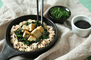 Tasty rice with tofu cheese in bowl on table