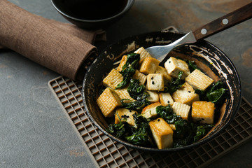 Tasty tofu cheese in bowl on grey table