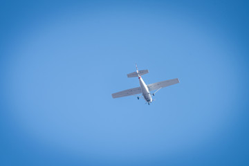 A small white plane flying in the sky