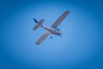 A small white plane flying in the sky