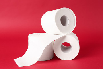 Rolls of toilet paper on color background