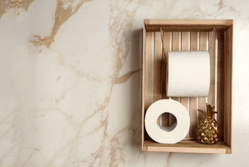Rolls of toilet paper with decor on light wall in restroom