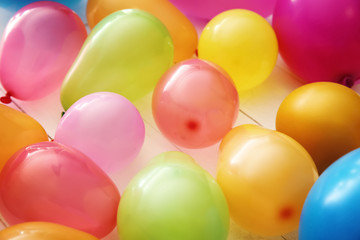 Fototapeta na wymiar Colorful balloons on white wooden background