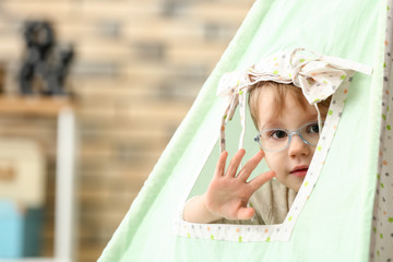 Portrait of cute little boy in hovel at home