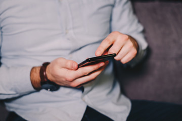 Young man surfing the internet on his smart phone.