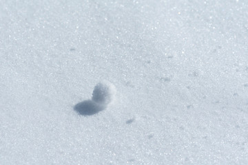 Little snowball on a snow background. Abstraction.  Selective focus. Beautiful background