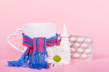 Mug of tea, pills, nasal spray. Disease, runny nose and tea. Illness and care. Mug with scarf