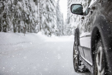 Car on a snowy winter road amid forests - using its four wheel drive capacities to get through the snow © lightpoet