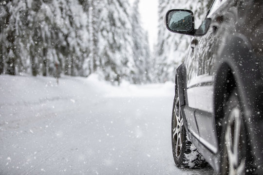 Car On A Snowy Winter Road Amid Forests - Using Its Four Wheel Drive Capacities To Get Through The Snow