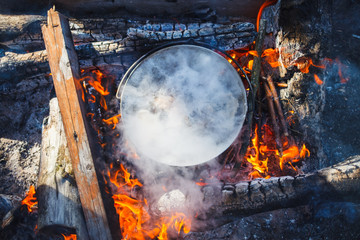 Cooking in a pot on the fire in the spring of red fish soup