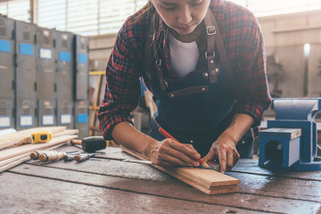Carpenter working with equipment on wooden table in carpentry shop. woman works in a carpentry shop.
