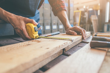 Carpenter working with equipment on wooden table in carpentry shop. woman works in a carpentry shop.