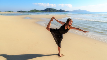 yoga on the beach, young girl in black, early morning, fog