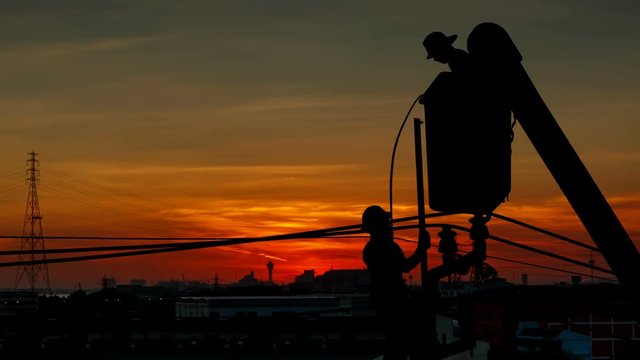 Silhouette Of An Electrician Climbing A Newly Installed Utility Pole With Sunset Time Lapse