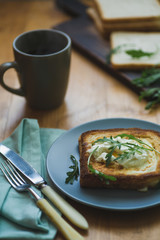 sandwich with egg and arugula on a plate is on the table