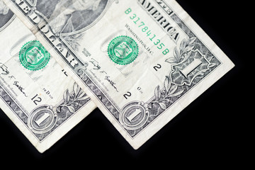 A few dollar bills on dark background close up