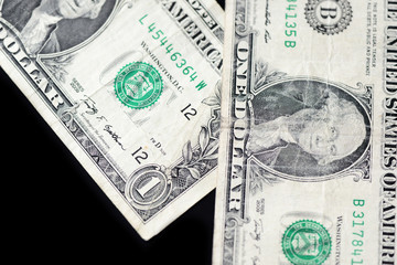 A few dollar bills on dark background close up