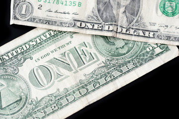 A few dollar bills on dark background close up