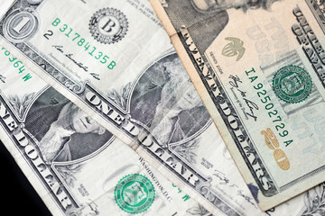 A few dollar bills on dark background close up
