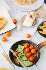 Frying pan with roasted cherry tomatoes and cucumbers.