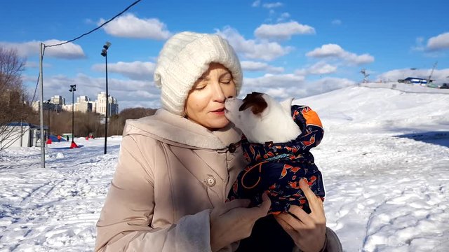 Adult woman hold her puppy outdoors