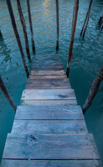 Fototapeta premium Wooden stairs into a canal in Venice