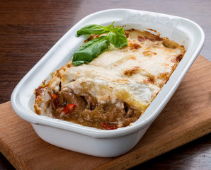 Lasagna with a rabbit in a ceramic bowl.