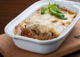 Lasagna with a rabbit in a ceramic bowl.