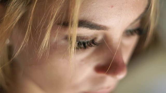 Close up face woman looking down. Portrait sad woman. Female face, eyes, eyelashes and eyesbrows. Natural beauty and makeup.